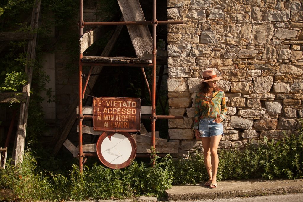 Scaffolding holding up a condemned building with a sign reading: "E' vietato l'accesso ai non addetti ai lavori." Your Tuscansunflower is leaning on the wall next to it.